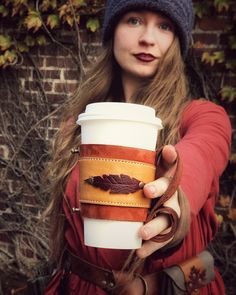 a woman holding a coffee cup in her hand