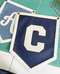 two blue and white pennants with the letter c on them sitting next to each other