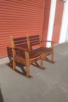 a wooden bench sitting in front of a red wall next to a closed garage door