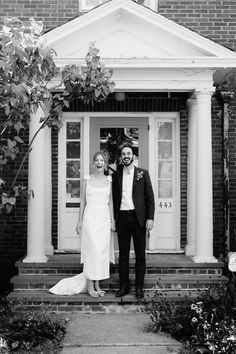 a man and woman standing in front of a house