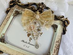 an ornate frame with pearls and bows on it