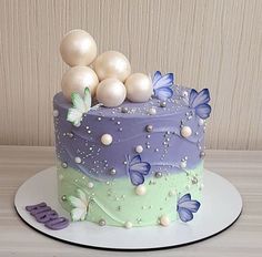 there is a cake with butterflies on the top and purple frosting in the middle