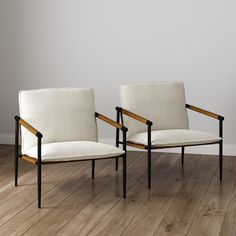 two chairs sitting next to each other on top of a wooden floor