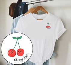 "Our \"Cherry Nice\" tee features a cute left chest print. This yummy design will be your new favorite shirt that you reach for again and again! * Q U I C K * F A C T S * ♥ Made from 100% Airlume combed and ringspun cotton ♥ Design is high quality digital print ♥ Wash and dry normally (on cool for best results) * S I Z I N G * ♥ Sizing is unisex so runs like men's, though not overly large ♥ Most women find their typical size works best, since they are meant to fit a touch loose ♥ Please see size guide in listing photos for all measurements and information * S H I P P I N G * T I M E S * ♥ Our items are custom made to order with love  ♥ We're working as quickly as possible and know speed is important! Our processing time is UP TO 7 business days but typically 2-5 business days, plus standar Cotton T-shirt With Cherry Print And Crew Neck, Cotton Crew Neck T-shirt With Cherry Print, Cotton Cherry Print Crew Neck T-shirt, Cute Crew Neck T-shirt With Cherry Print, White Crew Neck T-shirt With Cherry Print, Cherry Shirt, Fruit Shirt, Cool Tees, To My Daughter