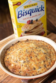 a box of bisquick next to a pancake on a wooden cutting board