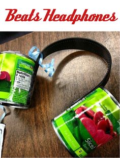 two canisters sitting on top of a wooden table next to a camera strap