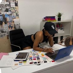 a woman sitting at a desk using a laptop computer