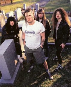 a group of young men standing next to each other in front of tombstones and headstones