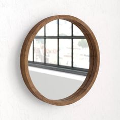 a round mirror hanging on the wall next to a window