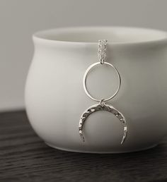 Adorn yourself with this remarkable sterling silver Two Cups Circle and Hammered Crescent Moon Necklace. This beautiful piece of jewelry has a minimalist style that is sure to make you feel like a goddess. The multifaceted symbolism of the full and half moon pendants is perfect for connecting to your spirituality. Make a statement with this elegant and timeless piece. Upside down Moon Necklace Sterling Silver Good Luck Zen Pagan Celestial Pendant Jewelry Gift for her Celestial Jewelry, Lunar Cha Minimalist Silver Moon Necklace, Minimalist Silver Necklace With Moon Charm, Minimalist Moon Shaped Nickel Free Necklaces, Minimalist Nickel Free Moon Necklaces, Everyday Silver Jewelry With Moon Charm, Minimalist Nickel-free Moon Necklace, Hypoallergenic Sterling Silver Crescent Jewelry, Hypoallergenic Crescent Sterling Silver Jewelry, Everyday Hypoallergenic Moon-shaped Jewelry