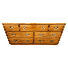 an old wooden dresser with many drawers on it's sides and brass handles, against a white background