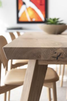 a wooden table with chairs around it and a bowl sitting on top of the table