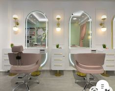 two salon chairs in front of mirrors with lights on the wall behind them and an oval mirror above it