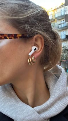 a woman wearing sunglasses and ear piercings