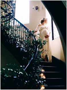 a woman in a white dress is standing on the stairs