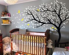 a baby's room with a tree painted on the wall