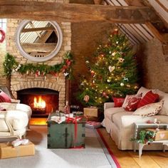 a living room filled with furniture and a christmas tree in the corner next to a fire place