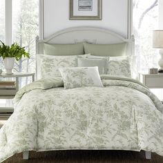 a bed with green and white comforters in a bedroom