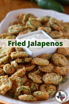 fried jalapenos on a white plate with a dipping sauce in the middle