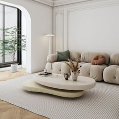 a living room with a couch, coffee table and potted plant in the corner