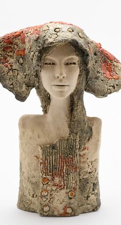 a ceramic sculpture of a woman with a hat on top of it's head