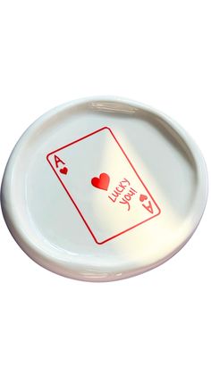 a white plate with red playing cards on the front and back of it that says i love you