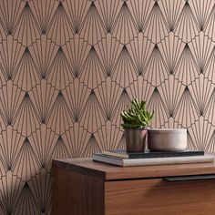 a wooden table topped with a potted plant next to a wallpapered wall