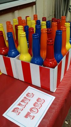 there are many different colored bottles in the box on the table and one is for sale