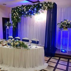 a banquet table set up with blue and white flowers