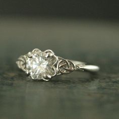 a close up view of a ring with a diamond in the center and filigrees on it