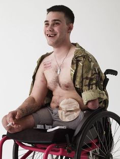 a man in a wheelchair with tattoos on his chest