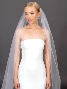 a woman wearing a wedding veil and dress