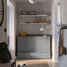 a baby's changing table in a room with shelves and hanging items on the wall