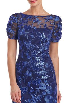 Sparkling sequins and floral embroidery illuminate this cocktail dress designed with an elongating neckline and a diipped back. 42" length (size 8) Hidden back-zip closure Bateau neck Short sleeves Lined 100% nylon Dry clean Imported Blue Floral Embroidery Evening Dress For Party, Blue Floral Embroidered Evening Dress For Party, Blue Floral Embroidery Evening Dress, Blue Evening Dress With Floral Embroidery For Party, Fitted Floral Applique Evening Dress For Party, Blue Fitted Evening Dress With Floral Embroidery, Fitted Blue Evening Dress With Floral Embroidery, Glamorous Fitted Floral Embroidered Evening Dress, Fitted Evening Dress With Floral Applique