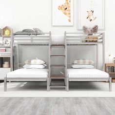 two bunk beds in a room with white walls and wood flooring on the side