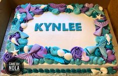 there is a cake that says kynlee on the top and shells around it