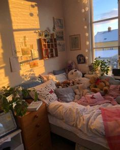 a bed with stuffed animals on it in a bedroom next to a window and desk