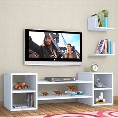 a flat screen tv mounted to the side of a wall next to bookshelves