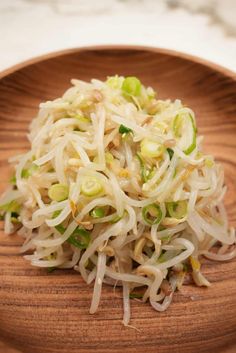 a wooden plate topped with coleslaw and sprouts