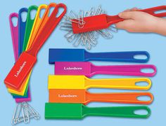 a hand holding a bunch of colorful plastic utensils with name tags on them