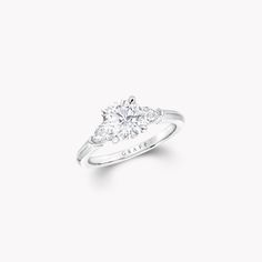 a three stone diamond engagement ring on a white background