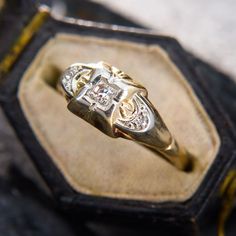 a gold and diamond ring sitting on top of a case