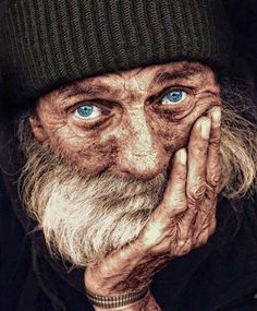 a painting of an old man with blue eyes and a long white beard wearing a beanie