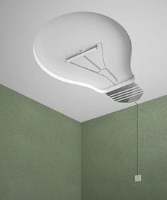 a light bulb suspended from the ceiling in a room with green walls and flooring