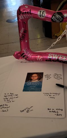 a pink bike frame sitting on top of a table next to a note and pen