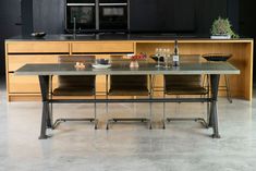 a kitchen with an island table and chairs