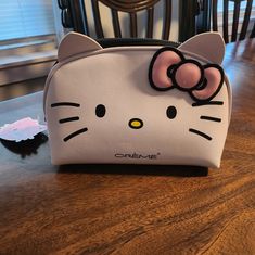 a hello kitty purse sitting on top of a wooden table