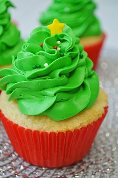 two cupcakes with green frosting and trees on top