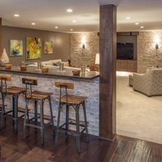 a living room filled with furniture and a bar in front of a tv mounted to the wall