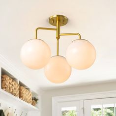 a kitchen with three lights hanging from it's ceiling and cabinets in the background